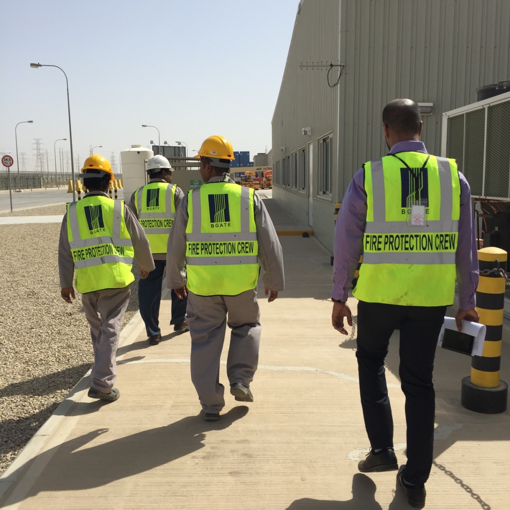 BGATE fire safety inspectors wearing safety vests and hard hats conducting an on-site project walkthrough.